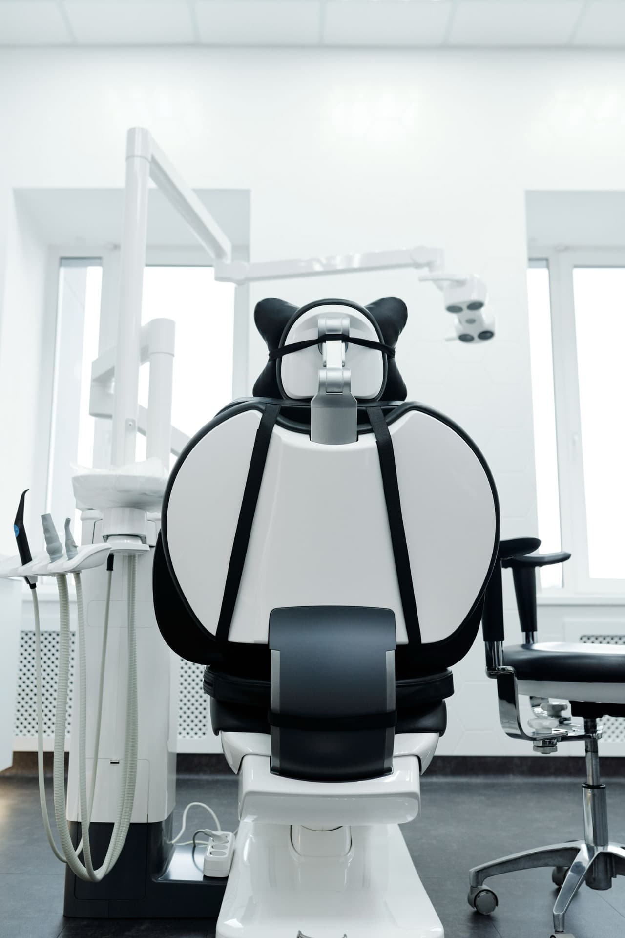 Modern dental operatory chair with overhead treatment light and instrument tray in a clean clinical room